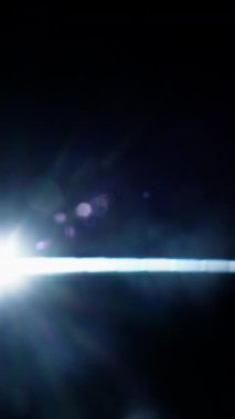 Parlak dairesel bir ışık, koyu bir arkaplan boyunca zarifçe parlar, çarpıcı bir kontrast ve parlak bir ışık yaratır.