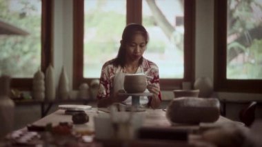 Bir modelleme aracı kullanarak çanak çömleğe hassas desenleri dikkatlice oyan zanaatkarlık ve detaylara dikkat