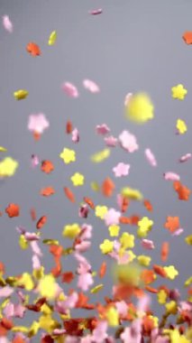 Çiçek şeklindeki şeker serpintileri yumuşak gri bir arka plana hafifçe asılmış.