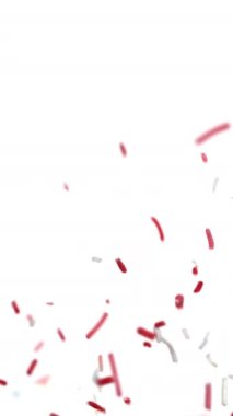 Kırmızı ve beyaz şeker serpintileri temiz beyaz bir zemin üzerinde neşeyle yüzer, neşeli ve kaprisli bir atmosfer yaratır