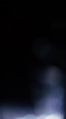 İlahi beyaz bokeh küreleri yavaşça karanlık, sakin bir arka plana doğru yükseliyor, huzurlu, rüya gibi bir atmosfer yaratıyor.