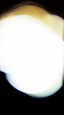 Parlak renkli bokeh çemberleri karanlık bir arkaplanda zarif bir şekilde süzülür büyüleyici ve canlı bir ışık gösterisi yaratır.