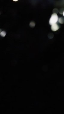 Yumuşak, parıldayan beyaz bokeh çemberleri karanlık bir arka plana hafifçe aydınlatılmış, rüya gibi ve zarif bir atmosfer yaratıyor.