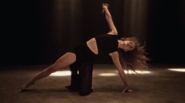 Çağdaş dans gösterisiyle büyüleyen bir kız zarif hareketlerini ve sanatını bir stüdyoda matris ışın lambalarıyla sergiliyor.