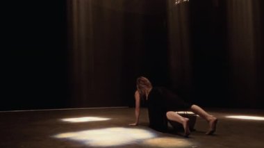 Bir bayan dansçı dramatik bir son poz vererek yerde yatar ve dansını bir stüdyo stüdyosundaki matris ışın ışıklarıyla sonlandırır.