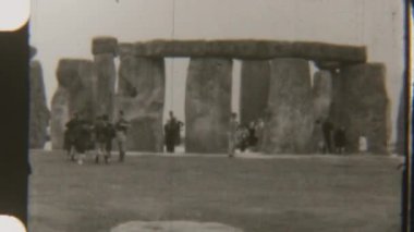 Siyah-beyaz görüntüler, arka planda antik taşların yükseldiği ikonik Stonehenge 'i keşfeden turistleri çekiyor.