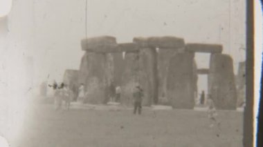 Stonehenge 'in mistik taşlarını keşfeden turistlerin siyah ve beyaz görüntüleri, antik anıtın önünde dururken şaşkınlıklarını ve meraklarını yansıtıyor.