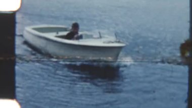 Genç bir çocuk, sakin ve huzurlu bir günde teknesini güvenli bir şekilde 8 mm 'lik bir filme çekmiş.