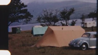 Nostaljik bir 8 mm 'lik çekim, canlı dağlık çayırlara kurulmuş kamp alanının manzaralı görüntüsünü yakalıyor. Renkleri, klasik film tahılları tarafından yumuşakça susturuluyor.