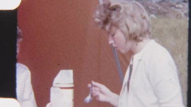 8mm 'lik bir fotoğraf, kardeşlerin doğayla iç içe olan rahat çadırlarının dışında görkemli bir kahvaltı ederken keyifli bir sabahı yakalıyor.