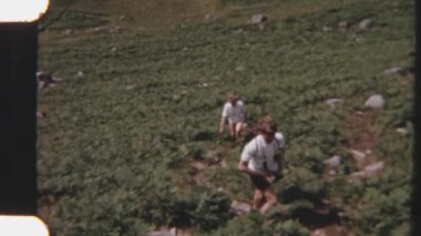 8mm 'lik gezginlerin dağın fırça gibi yamacında ilerlemelerini gösteren görüntüler. Düz olmayan arazide yürürken adımları temkinli.