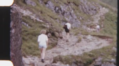 8 mm 'lik çekim, Rocky Dağı' nın engebeli arazisinde yürüyüş yapan kardeşleri yakalıyor, yüksek tepeler ve nefes kesici manzaralarla çevrili.