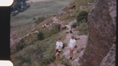 8 mm 'lik kardeşler maceraya başlarken engebeli dağ patikalarında arkalarından gelen diğer tatilcilerle birlikte yürüyorlar.