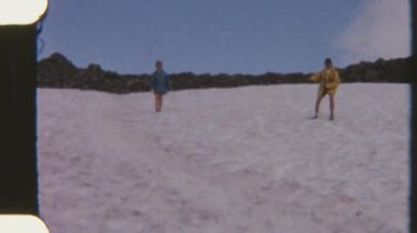 8mm 'lik maceraperestler açık mavi gökyüzünün altındaki eğimli karlı zeminde eğleniyor.