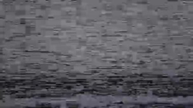 Bir VHS sinyali titreşimleri ve çarpıtmaları gösterir, yavaş yavaş mavi ekran efektine dönüşür, retro video oynatıcılığının nostaljik kusurlu estetiğini yakalar