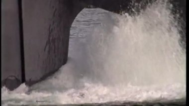 Bir yakın çekim, bir geminin gövdesinin alt kısmını su içinde hareket ederken yakalar ve çalkantılı bir uyanış yaratır.