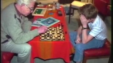 Bir VHS ev videosunda yaşlı bir adam ve torunu Noel arifesinde rahat bir evde satranç oynarken görülüyor. Çocuk bir sonraki hareketi hakkında derin düşüncelere dalmış ve adam sakince izliyor.