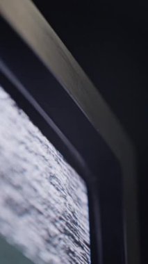 Ani bir sinyal düşüşünü gösteren bir VHS teyp kaydının dikey format görüntüsü, titreşen statik ile mavi bir ekrana dönüşüyor