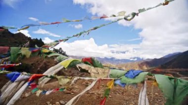 Rüzgarda dalgalanan renkli Tibet dua bayrakları görkemli Himalaya sıradağlarının çarpıcı zeminine vuruyor.