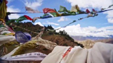 Rüzgarda dalgalanan renkli kutsal dua bayrakları, arka planda çarpıcı dağ sıraları, Nepal 'in Himalaya manzarasının ruhsal özünü yakalıyor.