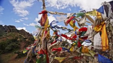 Rüzgarda dalgalanan canlı dua bayrakları Nepal dağlarının nefes kesen arka planına vuruyor.