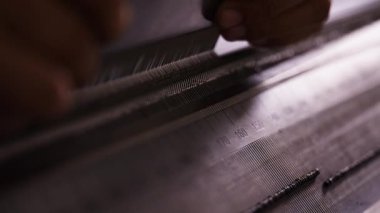 Elleri yakın plan örgü ekipmanları üzerindeki iğneleri elle ayarlamak, hassas ve pürüzsüz işlemler sağlamak