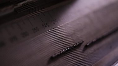 Bir tekstil örgü makinesine iğneler yerleştirirken, hassas ve pürüzsüz bir işlem sağlayan yakın plan çekimler.