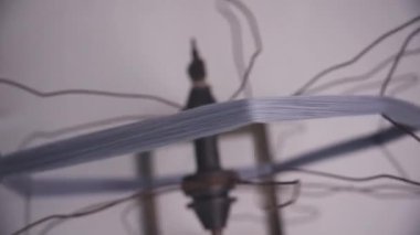 Dikiş ipliğinin, eğri büğrü bir tel makaraya sorunsuzca sarılması, eşsiz, DIY iplik döndürme sürecini gözler önüne sermesi,