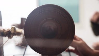 Geleneksel dönen tekerleğin üzerinde ustalıkla dönen beyaz ipliğin yakın plan çekimi, süreçte ustalığı ve hassasiyeti gösteriyor.