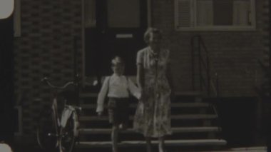 8 mm 'lik bir film, okula giderken çocuğunun yanında yürüyen bir anne, rutin olarak el ele yürüme rahatlığıyla özel bir hale getirildi.