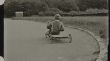 8 mm 'lik klasik bir film. Evde yapılmış sabun kutusu arabasıyla gezen genç bir çocuk. Yanında bisiklet süren bir kız, sakin bir sokakta çocukluk anılarını yakalıyor.