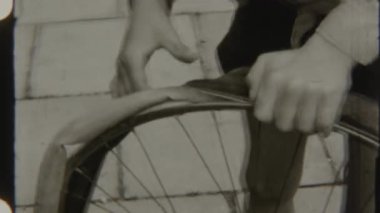 Bir çocuk tekerleği dikkatlice bisikletten ayırır. Tamir ya da temizlik için.