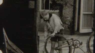 Bisikletinin lastiğini tamir etmeye odaklanmış genç bir çocuk, sürüş için iyi durumda olmasını sağlıyor.