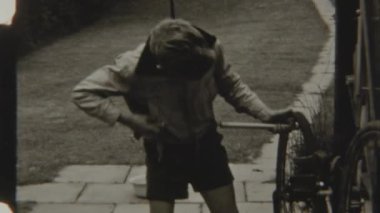 Kararlı bir çocuk bisiklet lastiğine hava eklemek için el pompası kullanır.