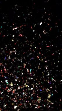 Renkli konfeti parçacıkları yavaşça karanlık bir arka plana doğru yükselirler, canlı ve kutlayıcı bir atmosfer yaratırlar.