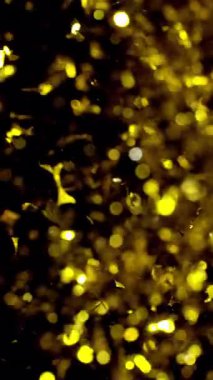 Havada parıldayan ve sürüklenen lüks altın bokeh konfetisinin büyüleyici gösterisi büyülü ve şenlikli bir atmosfer yaratıyor.