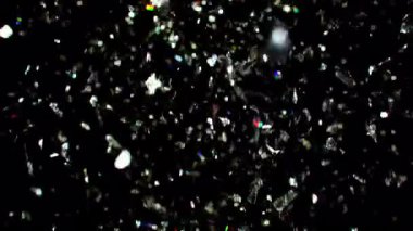 Parıldayan gümüş konfetilerin çarpıcı sağanağı siyah arka planda zarifçe yükselerek parıltılı ve şenlikli bir atmosfer yaratıyor.