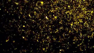 Göz kamaştırıcı bir altın konfeti yağmuru. Karanlık bir arka planda zarafetle çağlayarak şenlikli ve kutlayıcı bir atmosfer yaratıyor.