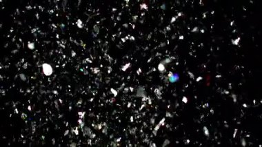 Işıldayan gümüş bir konfeti yağmuru. Arkaplanda zarafetle yayılıyor. Göz kamaştırıcı ve şenlendirici bir etki yaratıyor.