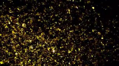 Sihirli altın konfetisinin büyüleyici yavaş çekim gücü yavaşça yukarı doğru sürükleniyor büyüleyici ve kutlayıcı bir atmosfer yaratıyor.