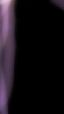 Yüksek voltajlı mor şimşekler çakıyor ve karanlıkta dalgalanarak siyah bir arka plana karşı çarpıcı bir elektrik enerjisi oluşturuyor.