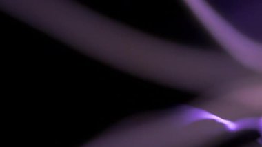 Soyut, yumuşak odaklı elektrik ışığı yavaşça karanlık ve sakin bir arka plan boyunca hareket ederek dinamik ve dinamik bir atmosfer yaratıyor.
