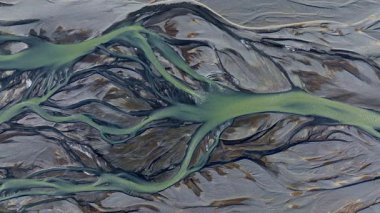 Sarmal örülmüş nehirlerin, buzul eriyen sulardan oluşan hava görüntüleri dramatik ve el değmemiş bir arazide engebeli lav alanlarını kesiyor.