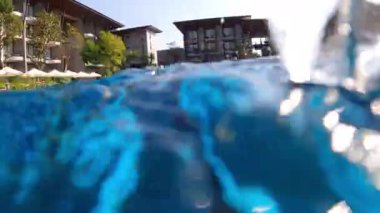 Bir turist sakin bir şekilde berrak sularda yüzer, deneyimi dinamik, birinci şahıs perspektifi için selfie çubuğuyla filme alır.