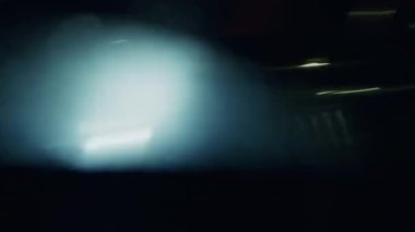 Neon ışığının kaotik dönüşü, kentsel görüntüyü kırbaç sesiyle hipnotik bir hız yanılsamasına dönüştürür.