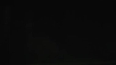 Hareketli bir şehrin neon ışıkları arasında dinamik kırbaç tepsisi, pürüzsüz, hareketli ışık geçişleri yaratıyor.