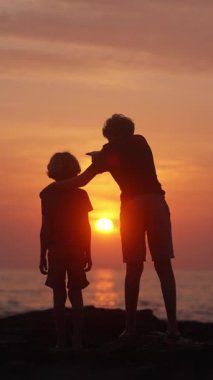 İki kardeş yan yana dururlar, güneş batarken uzak denize doğru yönelirler, bir bağ kurarlar ve merak ederler.