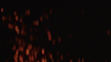 Yumuşak odaklı ateş parçacıkları yavaşça karanlık bir arka plana doğru yükselirler, ruhani ve dinamik bir görsel etki yaratır.