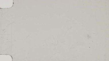 8 mm 'lik bir filmde görünür çizikler, toz parçacıkları ve aşınma izleri yer alırken, eskimiş otantikliği anımsatırken, koyu arkaplana doğru pürüzsüz renk değişimleri görülür.