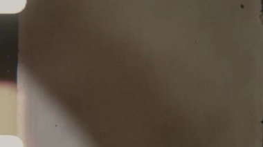 Otantik bir 8 mm 'lik film, ince buğdayla örtülmüş, sol kenarda hafif bir ışık sızıntısı, ve yıllanmış renk değişimi, yuvarlak köşeler ve nostaljik nostaljik hisleri uyandırmak için çıkıntılı delikler.